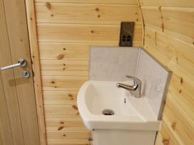 A bathroom with a sink and door at Lodge 2 Pontyates