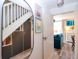 A hallway with a mirror and a cupboard at 21 Olympic Way Plymouth