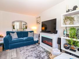 A living room with a sofa, TV, and fireplace at 21 Olympic Way Plymouth