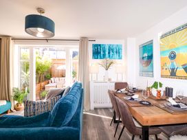 A living room with a sofa and dining area at 21 Olympic Way in Plymouth
