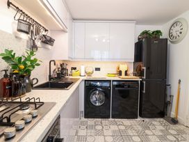A kitchen with a sink, gas stove, washing machine, and refrigerator at 21 Olympic Way in Plymouth
