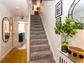 A hallway with a staircase and decorative plant at 21 Olympic Way Plymouth