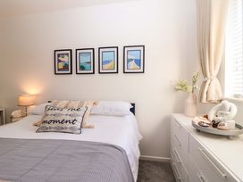 A bedroom with a bed, lamp, and framed pictures at 21 Olympic Way, Plymouth