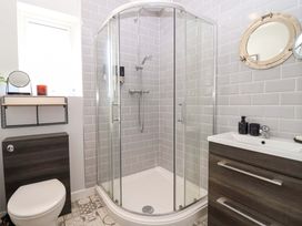 A bathroom with a shower, toilet, and sink at 21 Olympic Way Plymouth