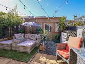 An outdoor garden with seating area and wooden cabin at 21 Olympic Way Plymouth