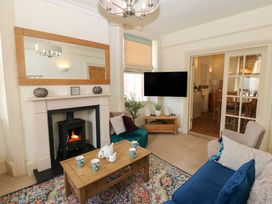 A living room with a fireplace and television at Hampton House in St. Bees