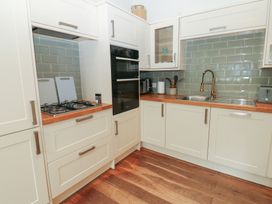 A kitchen with a gas stove and kitchen sink at Hampton House in St. Bees