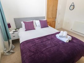 A bedroom with a double bed and towels at Hampton House in St. Bees