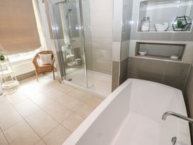 A bathroom with a bathtub and shower at Hampton House in St. Bees