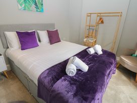 A bedroom with a bed and towels at Hampton House in St. Bees