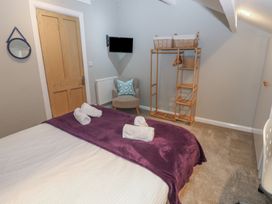 A bedroom with a bed and a chair at Hampton House in St. Bees