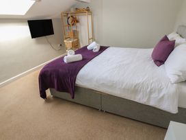 A bedroom with a bed and a television at Hampton House in St. Bees