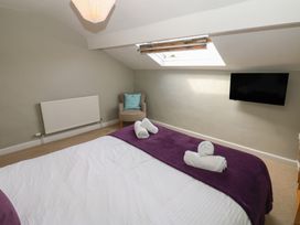 A bedroom with a bed and towels at Hampton House in St. Bees