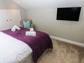 A bedroom with a bed and television at Hampton House in St. Bees