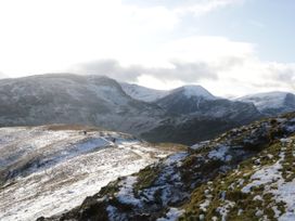 A landscape with snow-covered mountains and hikers at Hampton House St. Bees