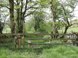 A wooden gate with a path leading into a grassy area at Hampton House in St. Bees