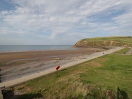 A beach with a pathway and grass area at Hampton House in St. Bees