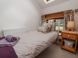 A bedroom with a bed and nightstand at Lane End North Molton