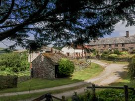 An outdoor view of a farm with buildings and trees at Lane End North Molton
