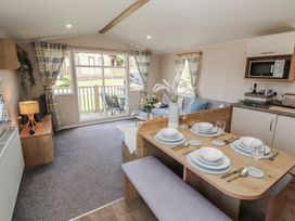 A living room with a dining area and kitchen at Barnes Retreat in Carnforth