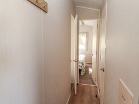 A hallway with doors to rooms and a window at Barnes Retreat in Carnforth