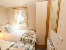 A bedroom with two beds and a mirror at Barneys Retreat in Carnforth