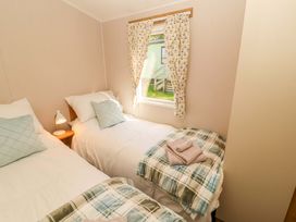 A bedroom with two beds and a window at Barneys Retreat in Carnforth
