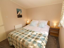 A bedroom with a bed and bedside tables at Barneys Retreat in Carnforth