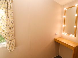 A dressing room with a mirror and lights at Barneys Retreat in Carnforth
