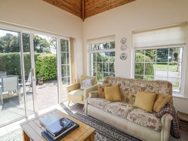 A conservatory with a sofa and armchair at Knockroe Lodge