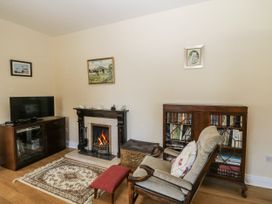 A living room with a fireplace and bookshelves at Knockroe Lodge