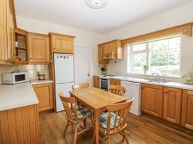 A kitchen with wooden cabinets and appliances at Knockroe Lodge