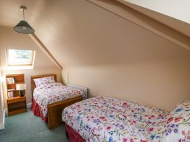 A bedroom with two beds and a bookshelf at Knockroe Lodge