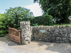 A gate with stone wall and sign at Knockroe Lodge