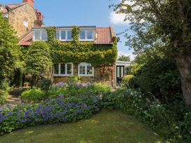 A house with flower beds and plants at Scalby Grove Cottage in Scalby