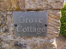 A sign reading Grove Cottage on a stone wall at Scalby Grove Cottage in Scalby