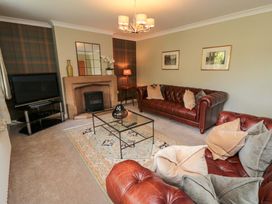 A living room with leather sofas and a television at Scalby Grove Cottage Scalby