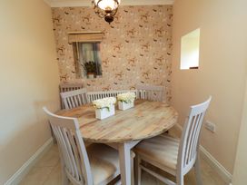 A dining room with a round table and chairs at Scalby Grove Cottage in Scalby