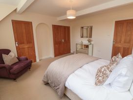 A bedroom with a bed and armchair at Scalby Grove Cottage in Scalby