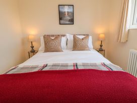 A bedroom with a bed and nightstands at Scalby Grove Cottage in Scalby