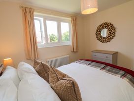 A bedroom with a bed and a window at Scalby Grove Cottage in Scalby