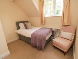 A bedroom with a bed and chair at Scalby Grove Cottage Scalby