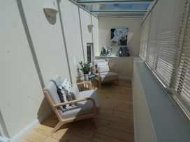 A conservatory with armchairs and a table at Scalby Grove Cottage in Scalby
