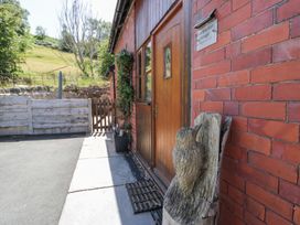 An entrance area with a wooden door and carved owl at Woodpecker Cottage in Llangollen