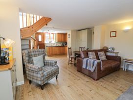A living room with a sofa and armchair at Woodpecker Cottage in Llangollen