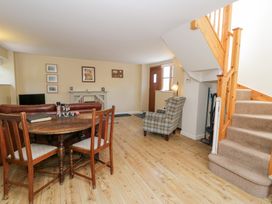 A living room with a dining table and sofa at Woodpecker Cottage in Llangollen