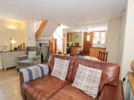 A living room with a sofa and an armchair at Woodpecker Cottage in Llangollen