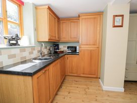 A kitchen with cabinets and a sink at Woodpecker Cottage in Llangollen