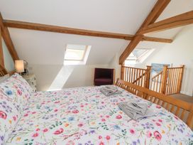 A bedroom with a bed and chair at Woodpecker Cottage in Llangollen
