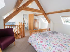 A bedroom with a bed and chair at Woodpecker Cottage in Llangollen